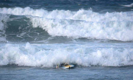 Surfer practicing his skills in the Atlantic ocean at Lanzarote, Spain