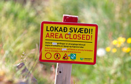 Yellow colored warning sign at the Latrabjarg, Icelandのeditorial素材