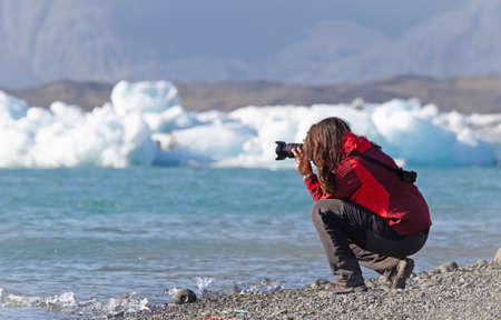 Woman walking over the beach at Jokulsarlon glacier lagoon in southern Iceland