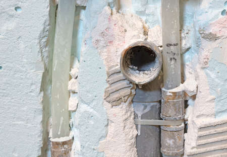 Drain pipe and water pipes in a plaster wall, under constructionの写真素材