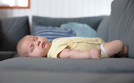 Newborn baby is sleeping on a couch, selective focusの写真素材