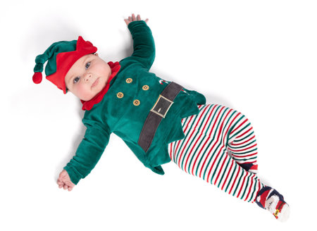 Baby wearing elf outfit - babies first Christmas, isolated on whiteの写真素材