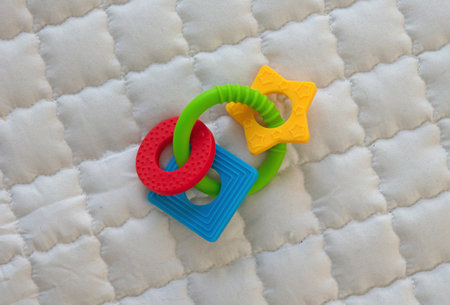Silicone teether ring for baby isolated on a baby play mat
