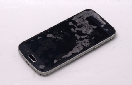 Black smartphone is lying in the water - Fallen in the bathtub