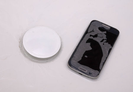 Black smartphone is lying in the water - Fallen in the bathtubの写真素材