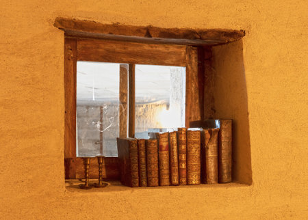 Old books on a row, old windowの写真素材