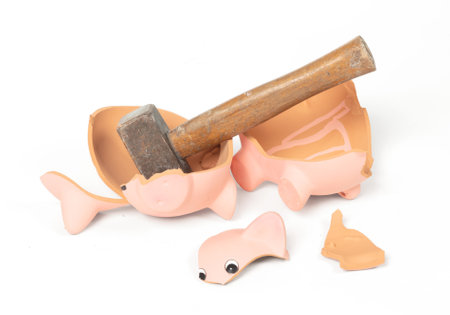 Hammer breaking piggy bank isolated on white