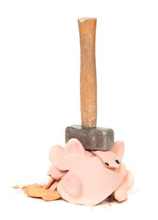 Hammer breaking piggy bank isolated on whiteの写真素材