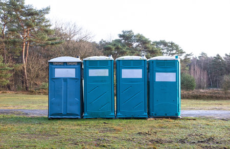 Four mobile toilets on a row in the Dutch forestの写真素材