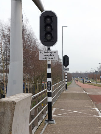Lights at a bridge, sign saying 'Clear bridge deck when bell rings - Clear the road when bell rings', selective focusの写真素材