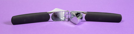 Used garlic press isolated on purple backgroundの写真素材