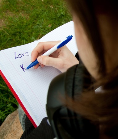 young girl writing in notebookの写真素材