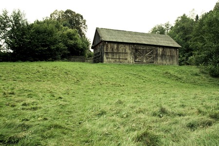 old wood vintage barn on a hill with grass in village museumの写真素材