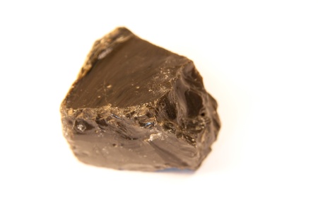 macro shot of obsidian, a volcanic glass isolated over white background