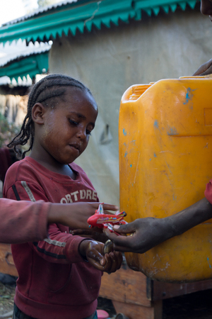 ethiopia child beside of a canister filled with waterのeditorial素材