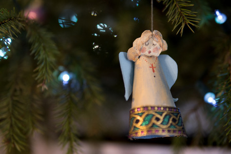 close up paper angel hanging on a christmas treeの写真素材