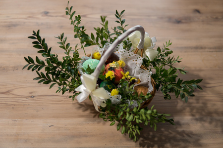 easter symbols inside of decorated basket on wooden table