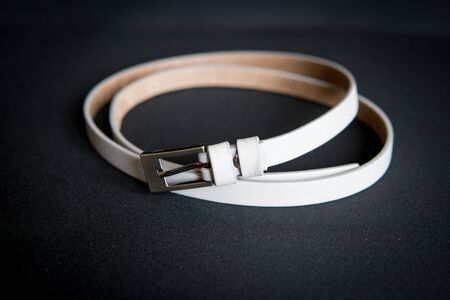 detail of a women's white belt isolated over black backgroundの写真素材