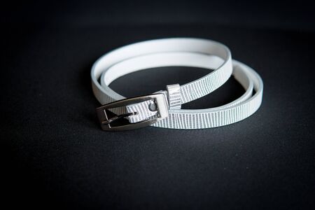 detail of a women's white belt isolated over black backgroundの写真素材