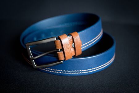 detail of men's blue belt isolated over black backgroundの写真素材