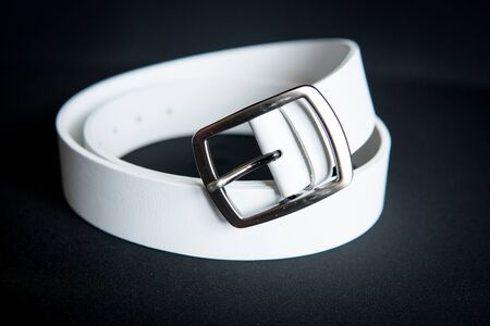 detail of a women's white belt isolated over black backgroundの写真素材