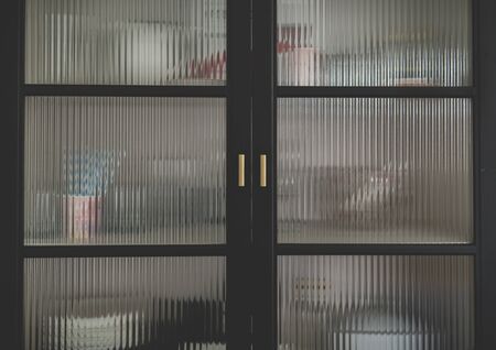 some dishware hidden inside of a furniture with corrugated glassの写真素材