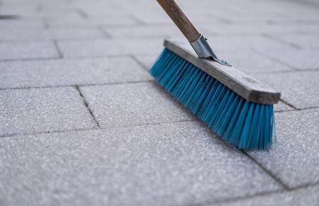 detail of blue brush used for cleaning pavemnet made from concrete stonesの写真素材