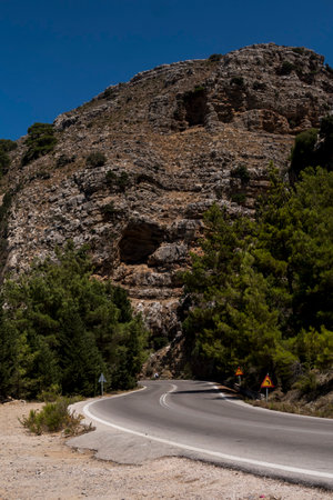Landscape with asphalt road in front of mountains during sunny day in Greeceの写真素材