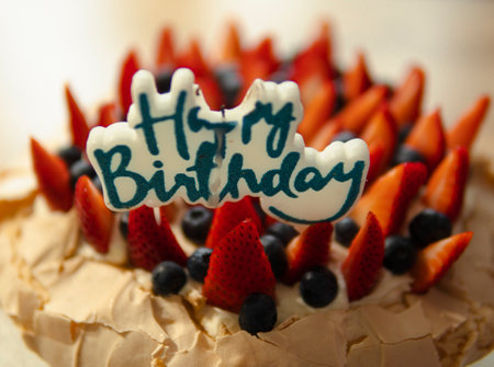 happy birthday candle on a cake with strawberries and blueberriesの写真素材