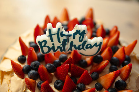happy birthday candle on a cake with strawberries and blueberriesの写真素材
