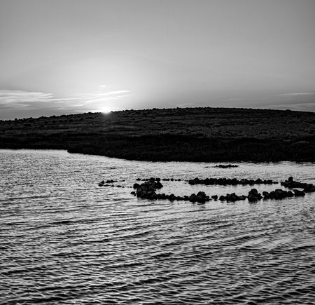 Sunset over island on Mediterranean Sea during summer seasonの写真素材
