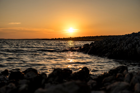 Sunset over island on Mediterranean Sea during summer seasonの写真素材