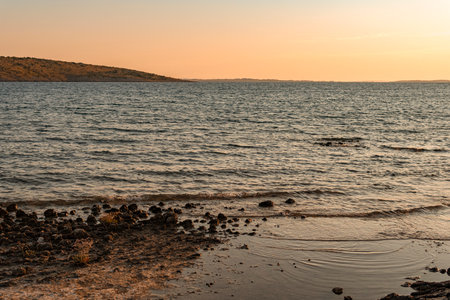 Sunset over island on Mediterranean Sea during summer seasonの写真素材