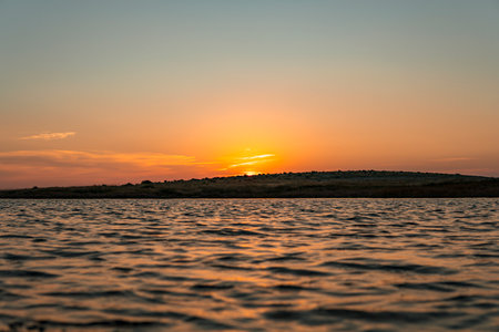 Sunset over island on Mediterranean Sea during summer seasonの写真素材