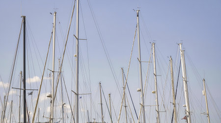 Empty masts of sailboats against a cloudless sky