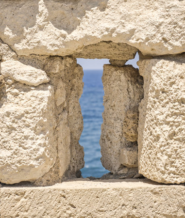 View through a window in the walls of the Venetian fortress in the town of Rethymno in Creteの写真素材