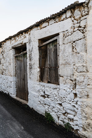 Destroyed white wall of abandoned building with wooden doorの写真素材