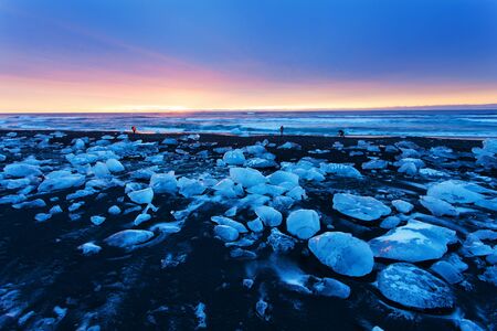 Sunrise in Jokulsarlon. icelandic ice lagoon of jokulsarlon in the morning in summer or winter. Blue icebergs floating in Jokulsarlon Glacier Lagoon, early winter in south Icelandの写真素材