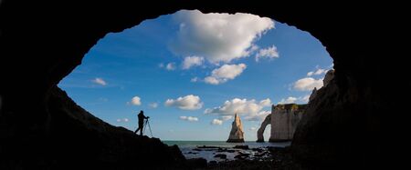 Picturesque panoramic landscape on the cliffs of Etretat. Natural amazing cliffs. Etretat, Normandy, France, English Channel. Coast of the Caucasus Pays in sunny summer day. Photographer on cliffの写真素材