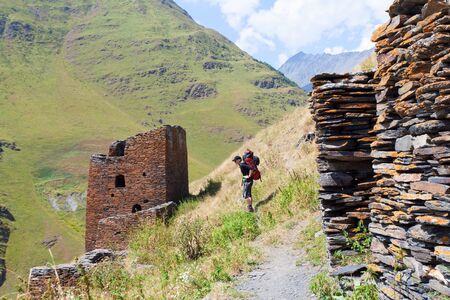 Summer landscape in Caucasus mountains. Sun just came out and illuminates the ancient ruins of Tushetian defensive towers. Trekking from Shalo, Atsunta Pass, Georgiaの写真素材