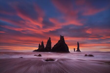 Reynisdrangar are volcanic basalt sea stacks situated under the cliffs of Reynisfjall mountain near...