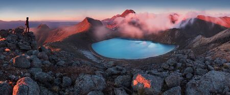 Early morning sunrise, scenery of blue lake, wild mountains and huge volcano