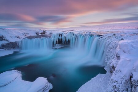 Godafoss waterfall at sunset - Views around Iceland, Northern Europe in winter with snow and ice. One of the most powerful waterfalls in Europe. Winter landscapeの写真素材