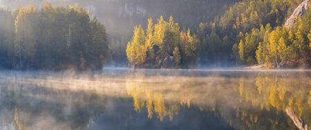Almost nearly perfect reflection of mountains. Near Calgary, Alberta. Autumn season is coming. Bear...