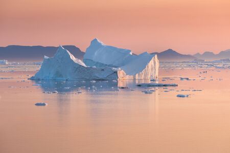 Photogenic and intricate iceberg under an interesting and blue sky during sunset. Effect of global...