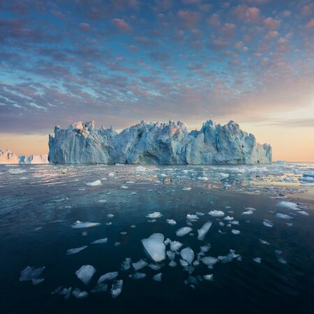 Photogenic and intricate iceberg under an interesting and blue sky during sunset. Effect of global...