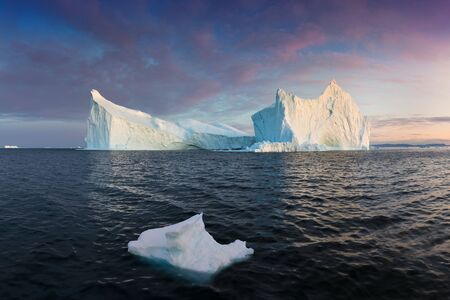 Photogenic and intricate iceberg under an interesting and blue sky during sunset. Effect of global...