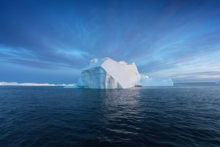 Iceberg at sunset. Nature and landscapes of Greenland. Disko bay. West Greenland. Summer Midnight...