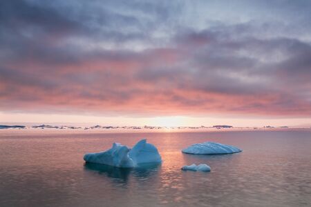 Greenland or Antarctica. Travel on ship among ices. Studying of global warming phenomenon Ices and icebergs of unusual forms and colorsの写真素材