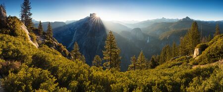 Half Dome and Yosemite Valley in Yosemite National Park during a colorful sunrise with trees and...